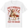 A person wearing a Love is Overrated Pass the Snacks VDay Cupid Vibes Shirt with a sarcastic Cupid graphic and retro typography.