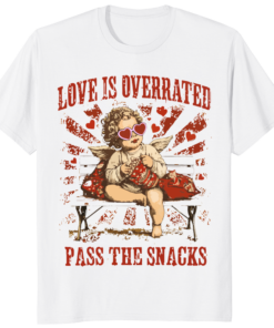 A person wearing a Love is Overrated Pass the Snacks VDay Cupid Vibes Shirt with a sarcastic Cupid graphic and retro typography.