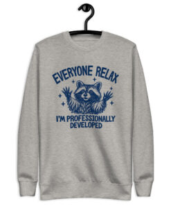 Carbon grey professionally developed raccoon sweatshirt with a navy raccoon raising its hands and Everyone Relax I'm Professionally Developed